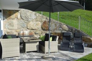 - une table et des chaises avec un parasol sur la terrasse dans l'établissement Appartement Wieshof, à Neukirchen am Großvenediger