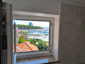 uma janela de casa de banho com vista para o oceano em Apartments & Room Marina View em Vodice