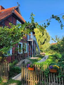 una casa con una valla y flores delante de ella en Hof KuMa, en Uelzen