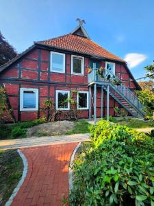 una casa con una pasarela de ladrillo delante de ella en Hof KuMa, en Uelzen