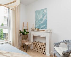 a bedroom with a fireplace and a bed and a chair at Apartament Aqua Przystań 80 - Rumia Novum in Rumia