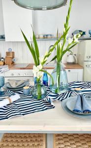 a kitchen table with plates and vases on it at Apartament Aqua Przystań 80 - Rumia Novum in Rumia