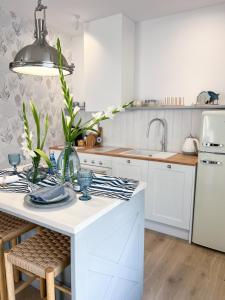 a kitchen with white cabinets and a white counter top at Apartament Aqua Przystań 80 - Rumia Novum in Rumia