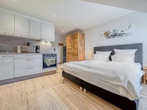 um quarto com uma cama grande e uma cozinha em TDYHOMES Hotel em Landstuhl