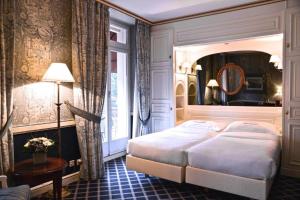 เตียงในห้องที่ Carlton Lausanne Boutique Hôtel