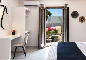 una camera con letto e sedia e un balcone di Santorinn Suites Fira a Firà