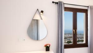 bagno con specchio e finestra di Santorinn Suites Fira a Firà