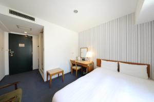 Cette chambre comprend un lit et un bureau. dans l'établissement Smile Hotel Nihombashi Mitsukoshimae, à Tokyo