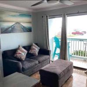 ein Wohnzimmer mit einem Sofa und einem Balkon in der Unterkunft Beachfront View Condo at Casa Del Mar in Galveston