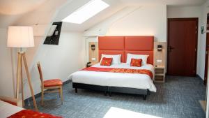 a bedroom with a large bed and a red headboard at Hôtel de L'ile in Custines