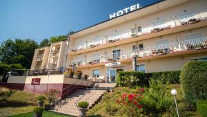 a hotel with stairs and flowers in front of it at Hôtel de L'ile in Custines