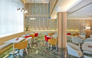 un ristorante con tavoli e sedie in una stanza di NH Collection Barcelona Podium a Barcellona