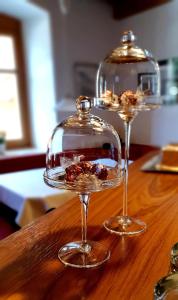 two wine glasses sitting on top of a wooden table at Glacier Rock guesthouse in Solda