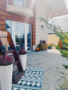 une maison avec une terrasse couverte ornée de plantes en pot dans l'établissement Cisza i Spokój, à Szczawnica