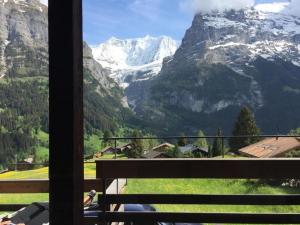 einen Balkon mit Blick auf die schneebedeckte Bergkette in der Unterkunft alleinstehendes Ferienhaus in Grindelwald