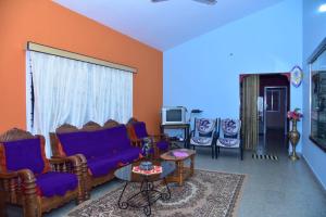 a living room with a blue couch and chairs at Rock peak view homestay in Avathi