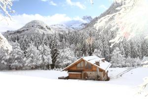 マドンナ・ディ・カンピリオにあるPra de la Casaの山を背景にした雪の小屋