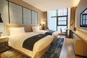 Cama ou camas em um quarto em Echarm Hotel Wuhan Optics Valley Software Park Juran Home