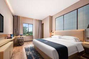 Cama ou camas em um quarto em Echarm Hotel Wuhan Optics Valley Software Park Juran Home