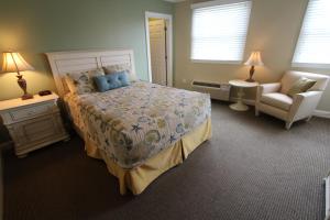 a bedroom with a bed and a couch and a chair at InnSeason Resorts HarborWalk in Falmouth