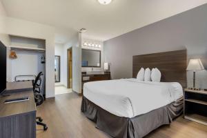 Rúm í herbergi á Super 8 by Wyndham Macleod Trail Calgary