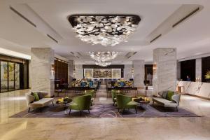 上海市にあるDoubletree By Hilton Shanghai Hongqiaoのホテルのロビー(椅子、テーブル、シャンデリア付)