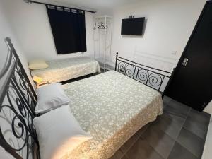 1 dormitorio con 2 camas y balcón con TV en ESTANQUEIRA GUEST HOUSE, en Sines