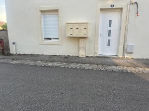 un edificio bianco con una porta e una finestra di Le petit nouveau avec Jardin a Pont-à-Mousson