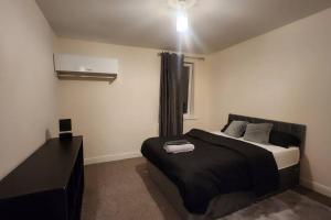 una camera con un letto nero e una finestra di 2 bedroom apartment a Liverpool