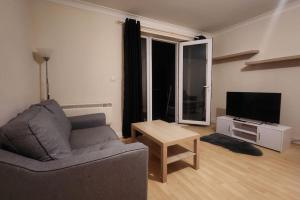 un soggiorno con divano, tavolo e TV di 2 bedroom apartment a Liverpool