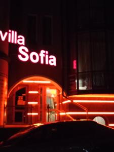 un panneau sur le côté d'un bâtiment avec un magasin dans l'établissement Villa Sofia, à Trouskavets