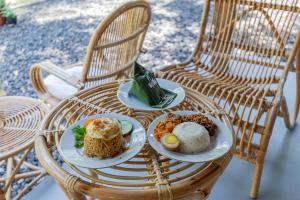 twee borden eten op een rieten tafel bij Yukke Tembi Homestay in Yogyakarta