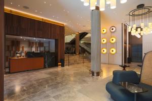 a lobby with a blue chair and a staircase at Hotel Liabeny in Madrid