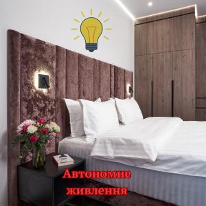 1 dormitorio con 1 cama con lámpara en la pared en BonApart Maidan by UHM, en Kiev