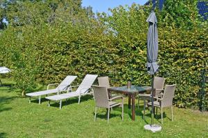 een tafel en stoelen met een parasol in het gras bij schoene Ferienwohnung mit Terrasse in Ralswiek