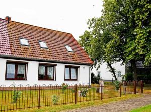 een wit huis met een hek ervoor bij schoene Ferienwohnung mit Terrasse in Ralswiek