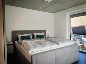 um quarto com uma cama grande e almofadas azuis em Apartments Patzina NEU 2024 - Kurort Oberwiesenthal em Kurort Oberwiesenthal