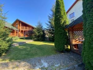 a yard with a house and a tree at Arnika in Skhidnitsa