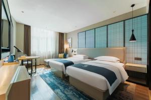 A bed or beds in a room at Echarm Hotel Guangzhou Panyu Shiqiao Subway Store