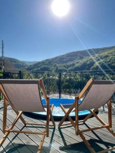 Duas cadeiras sentadas num deque com piscina em BRB Park Hotel em Vizhenka