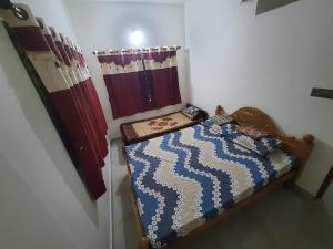 una piccola camera con letto e tende di Jk homestay Mysore a Mysore