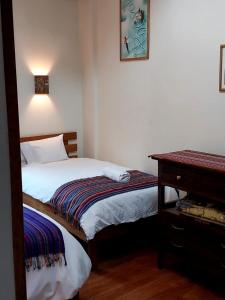 1 dormitorio pequeño con 2 camas y mesa en Maison Fortaleza, en Cusco