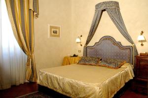 a bedroom with a bed with a canopy at Hotel Clitunno in Spoleto