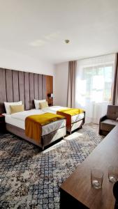 a hotel room with two beds and a couch at Hotel Korona Spa & Wellness in Lublin