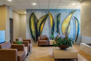 una sala de espera con sillas y una pintura en la pared en Days Inn & Suites by Wyndham West Edmonton, en Edmonton