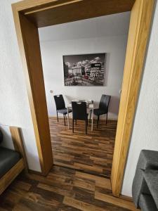 una sala da pranzo con tavolo, sedie e specchio di FERIENWOHNUNG APARTMENT in ZITTAUER STADTZENTRUM INNENSTADT INNENRING TOP LAGE - WOHNEN AUF ZEIT IN ZITTAU - 1 RAUM WOHNUNG a Zittau