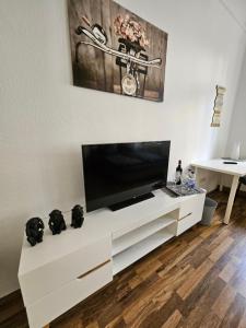 un centro di intrattenimento bianco con TV a schermo piatto di FERIENWOHNUNG APARTMENT in ZITTAUER STADTZENTRUM INNENSTADT INNENRING TOP LAGE - WOHNEN AUF ZEIT IN ZITTAU - 1 RAUM WOHNUNG a Zittau