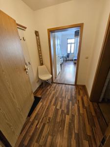 un corridoio vuoto con una porta e una sedia di FERIENWOHNUNG APARTMENT in ZITTAUER STADTZENTRUM INNENSTADT INNENRING TOP LAGE - WOHNEN AUF ZEIT IN ZITTAU - 1 RAUM WOHNUNG a Zittau