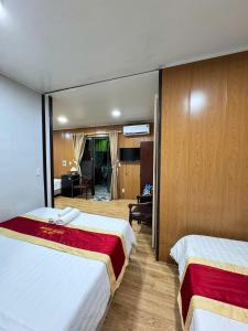 Habitación de hotel con 2 camas y sala de estar. en Phúc Đạt Container, en Vung Tau