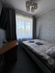 Un dormitorio con una cama grande y una ventana en Paradize, en Daugavpils